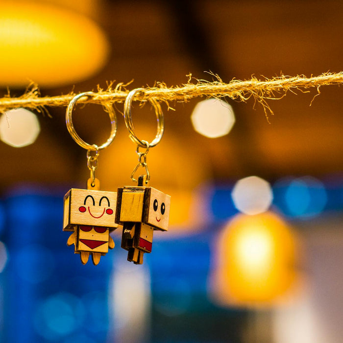 Close-up of cute toy keychains hanging on a string with bright bokeh lights in the background.