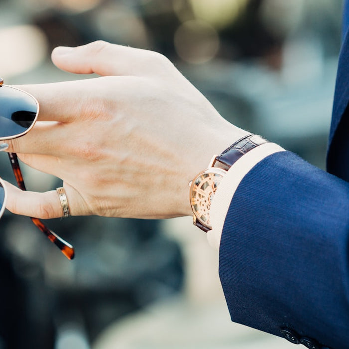 shallow focus photography of man holding sunglasses