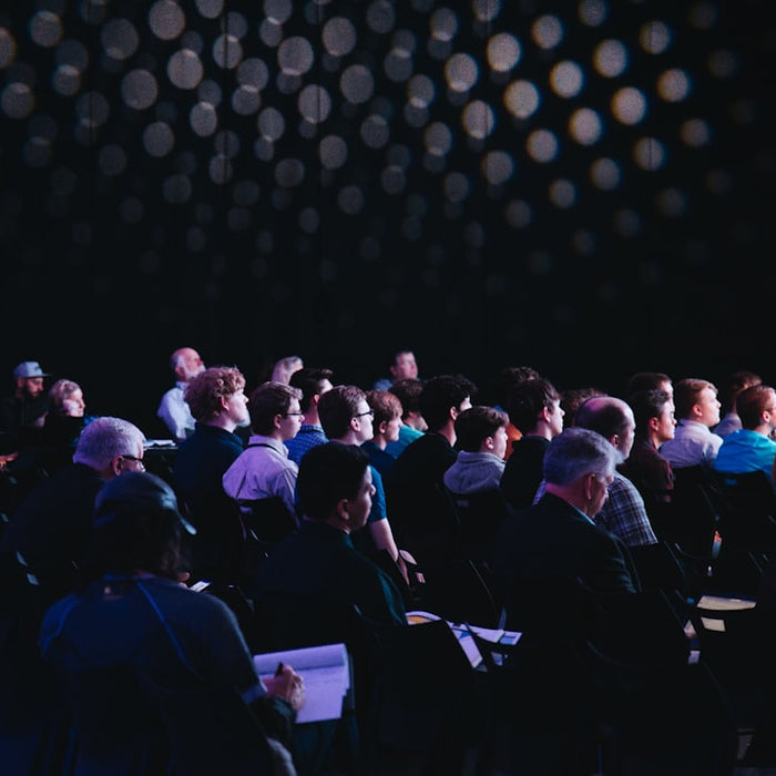crowd of people sitting on chairs inside room