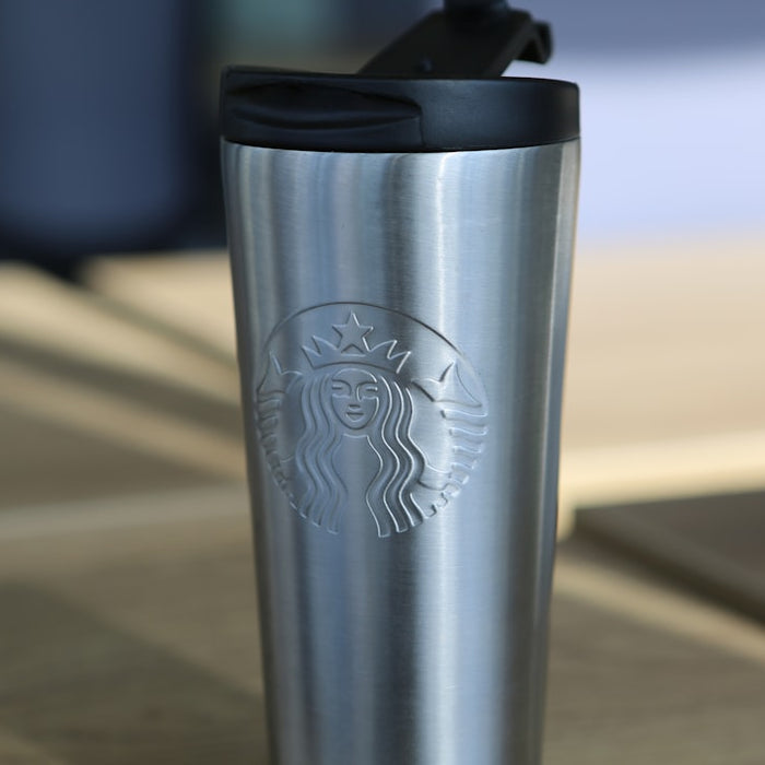silver starbucks travel mug on brown wooden table