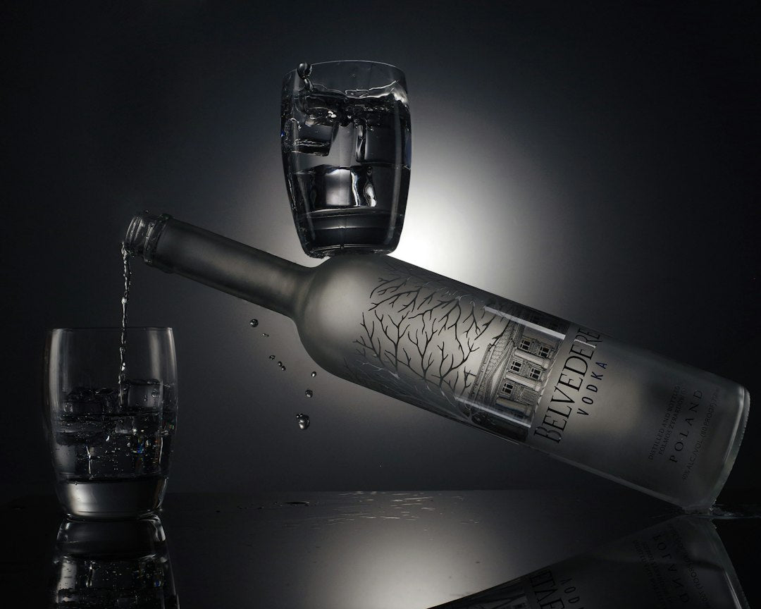 clear drinking glass beside silver bottle