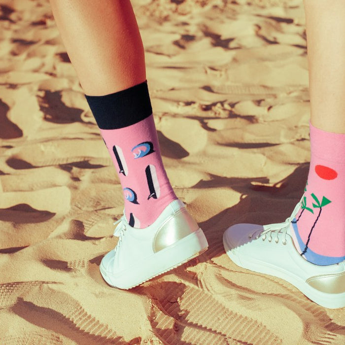 a person standing in the sand with their feet up