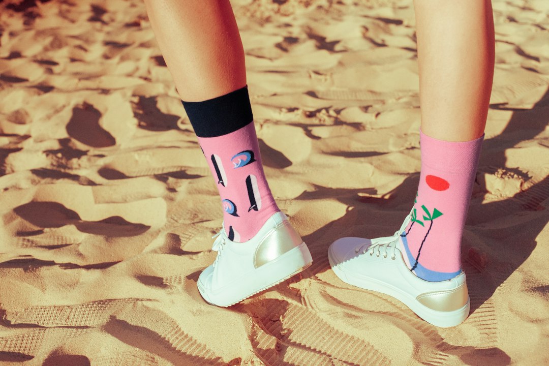 a person standing in the sand with their feet up