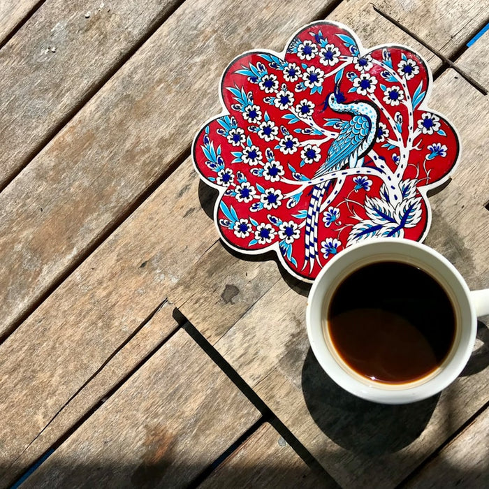 a cup of coffee sitting on top of a wooden table