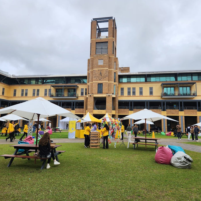 A group of people sitting on top of a lush green field