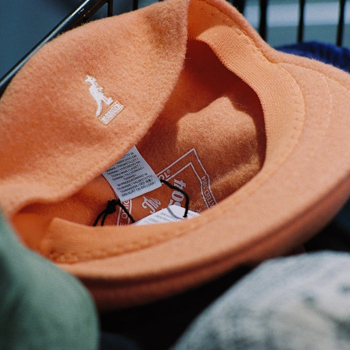 A shopping cart filled with different colored hats