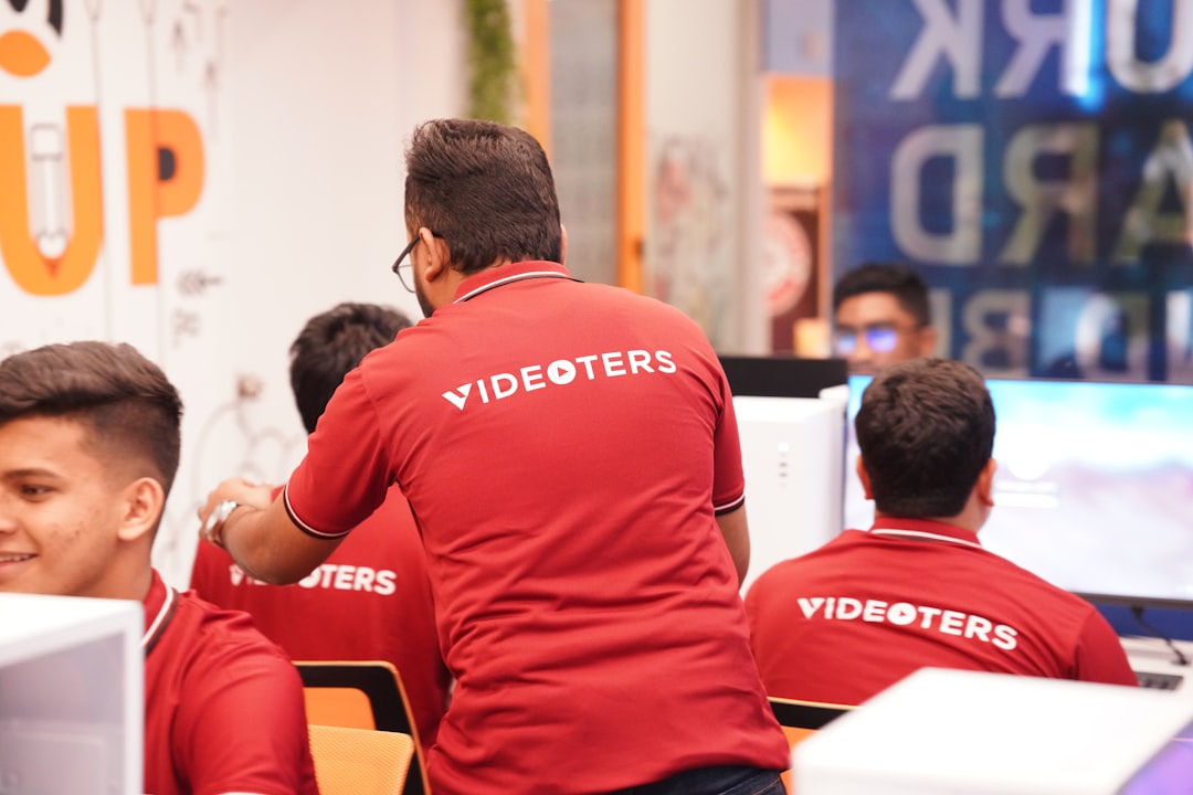 A group of men in red shirts working on computers