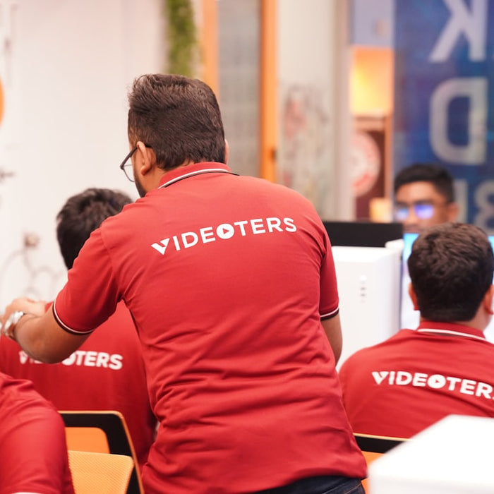 A group of men in red shirts working on computers