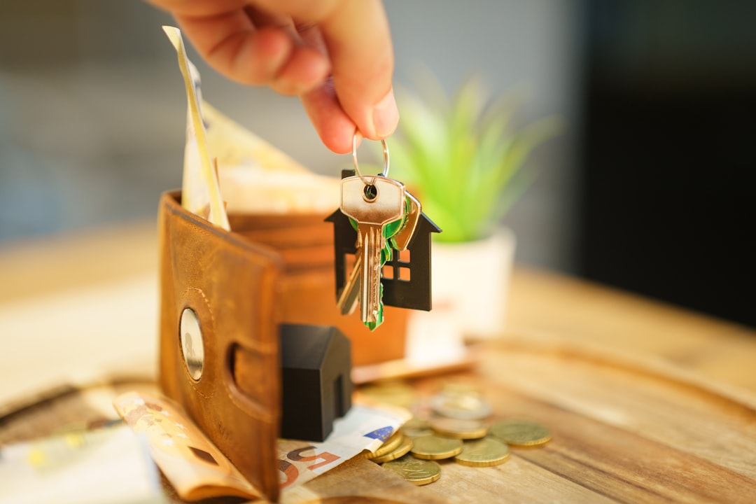 Hand holding keys with house charm and wallet
