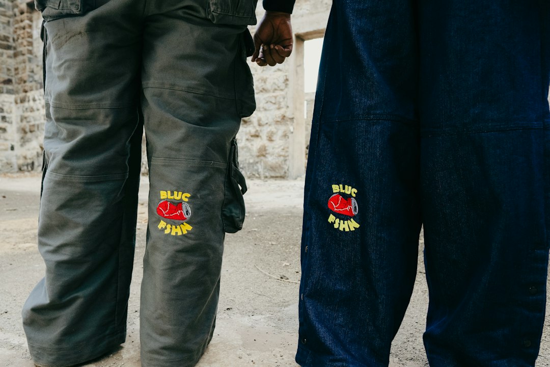 Two people stand in blue and grey pants