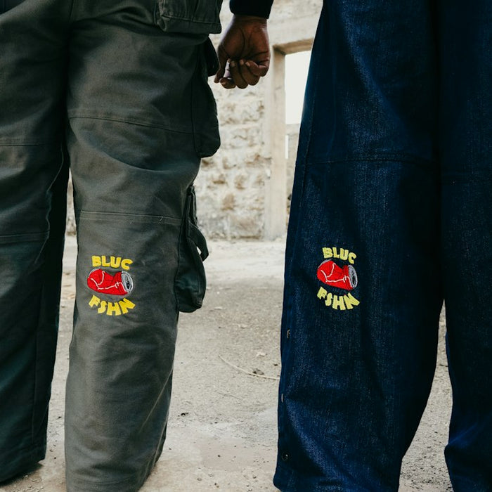 Two people stand in blue and grey pants