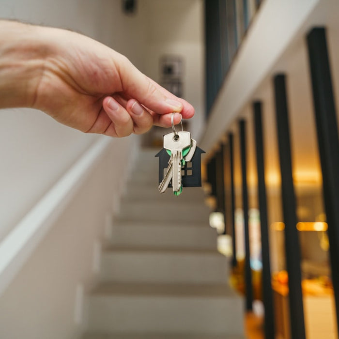 Here's a possible caption: keys being held in front of a staircase.