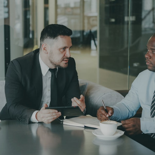 Two businessmen discussing work over coffee.