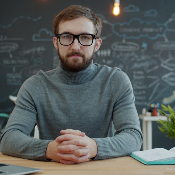 Man with glasses sitting at desk in office