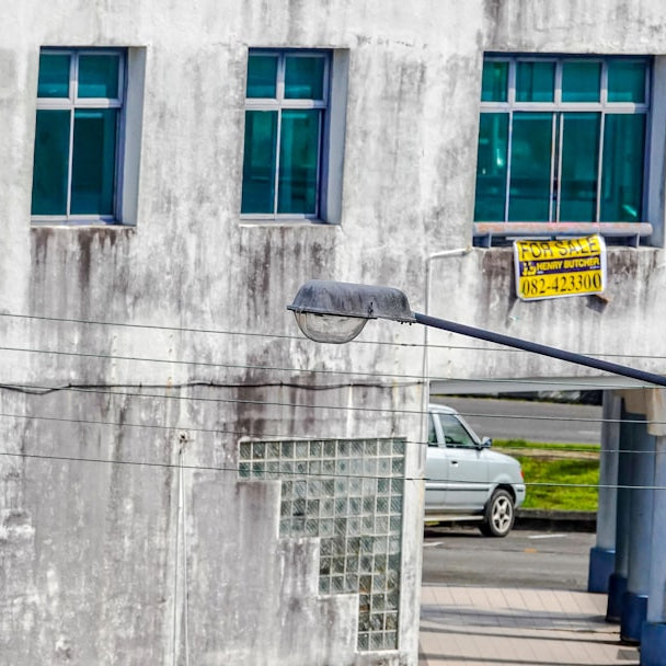 Weathered building facade with windows and street light.