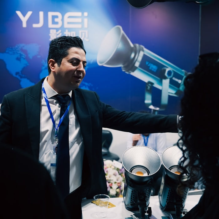 Man in suit presenting equipment at a trade show.