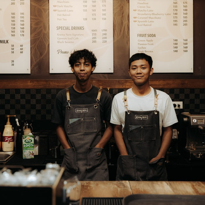 Two baristas smiling behind a counter