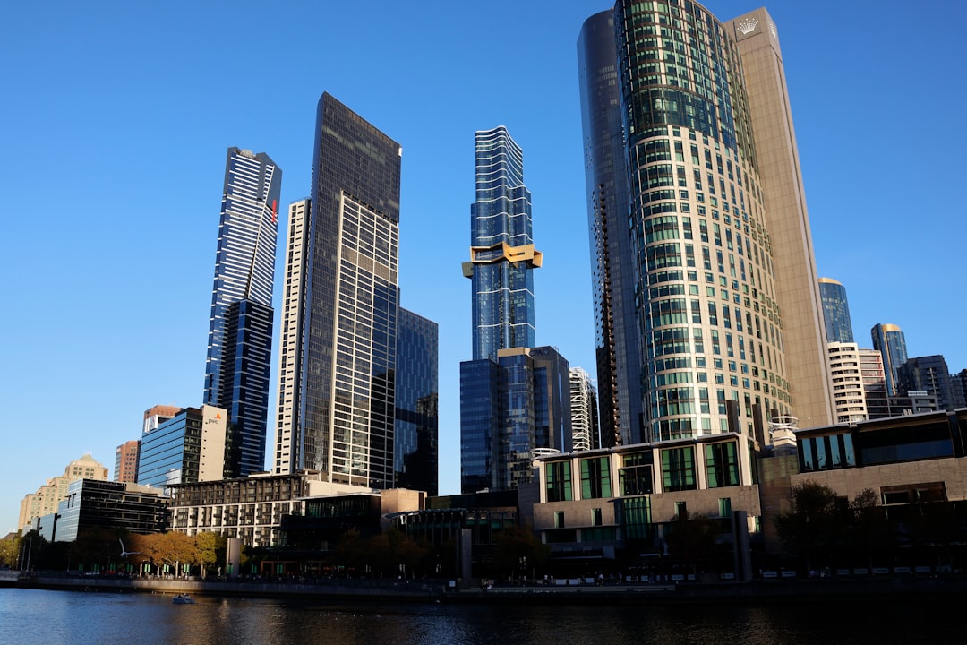 Modern skyscrapers rise against a clear blue sky.