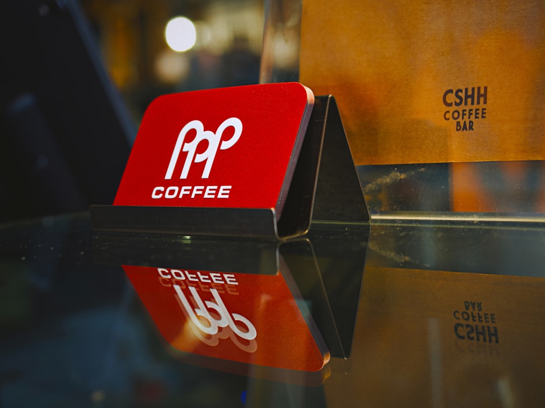 Red coffee sign with logo reflects on glass surface