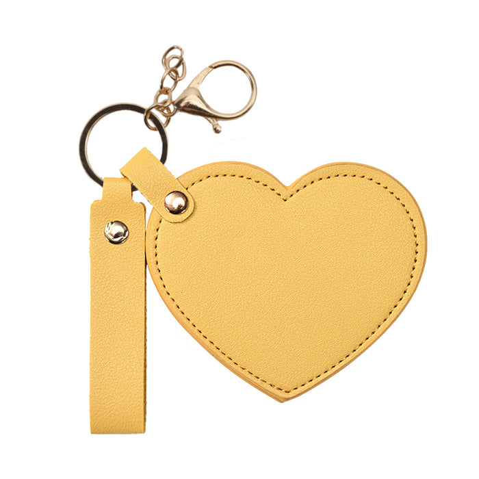Heart-Shaped Compact Mirror with Keychain - A heart-shaped compact mirror in yellow with a keychain attachment and a clip for easy carrying.
