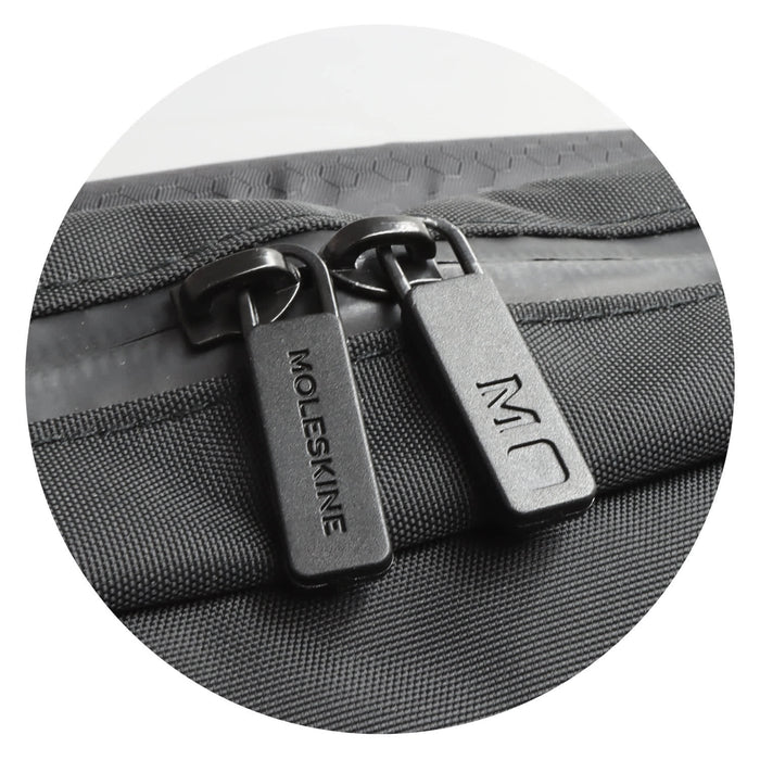 Moleskine Metro Slim Backpack - A zip detail of a black Moleskine Metro Slim Backpack featuring dual zippers and a textured surface.