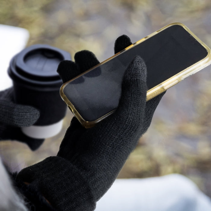 Himalaya Tech Gloves - Black Himalayan Tech Gloves holding a smartphone, with a coffee cup partially visible in the background.