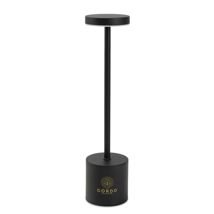 Nouveau Rechargeable Table Lamp - A black rechargeable table lamp with a cylindrical base and a circular top, featuring a logo on the base.