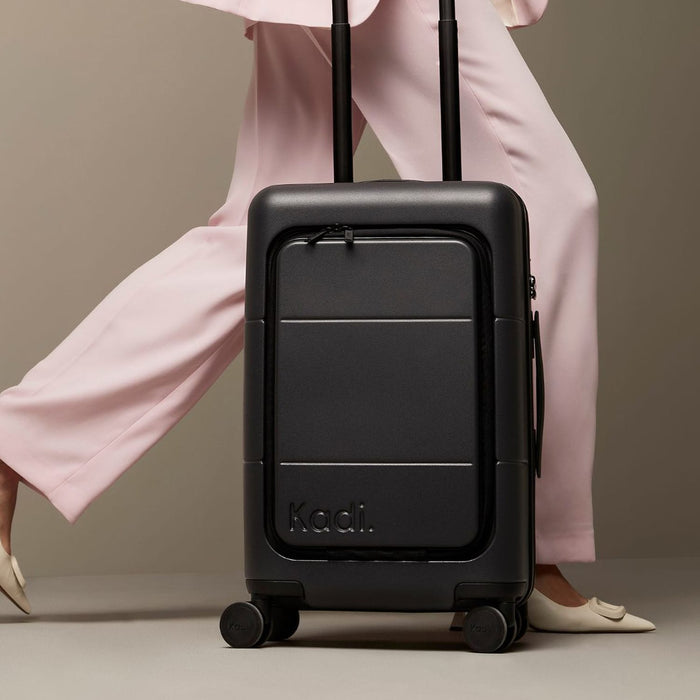 Kadi Carry-On Suitcase - Business - A black carry-on suitcase with wheels and a retractable handle, featuring branding on the front.