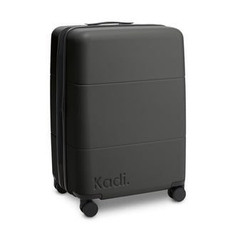 Kadi Check-In Suitcase - Medium - A medium suitcase in black with a textured surface and four wheels, featuring a logo.