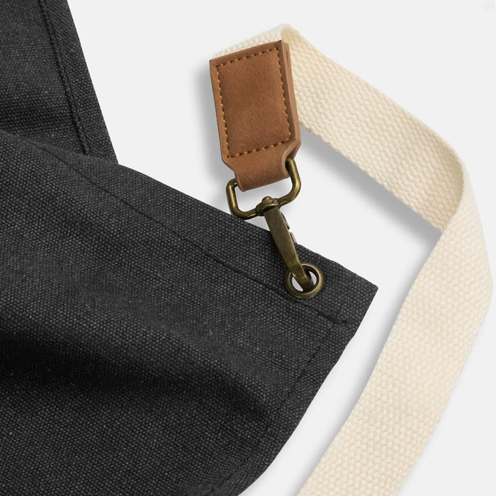 Keepsake Canvas Apron & Oven Mit Set - A dark grey canvas apron featuring a leather strap and a brass clip attachment.