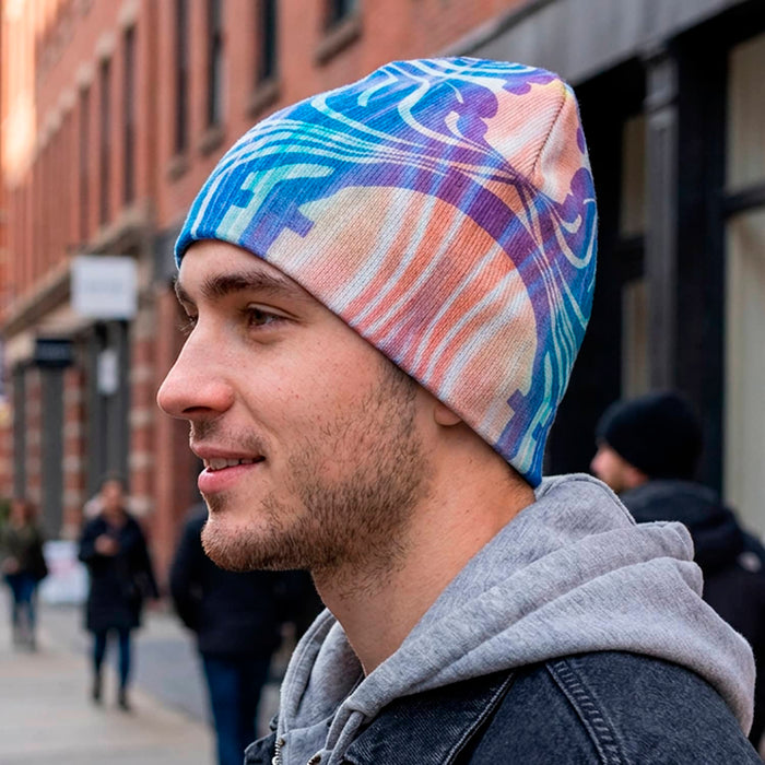 Commando Custom Full Colour Beanie - A full colour beanie featuring a vibrant abstract design, worn by a young man in a casual outfit on a city street.