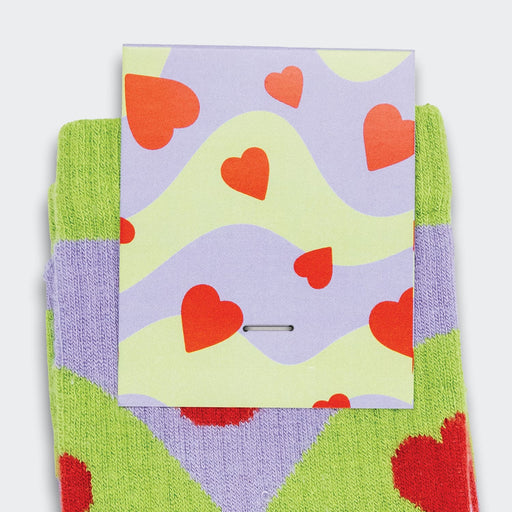 Pixel Knitted Bamboo Grip Socks - Bright green and purple knitted socks featuring a heart pattern, with a card displaying a similar design.