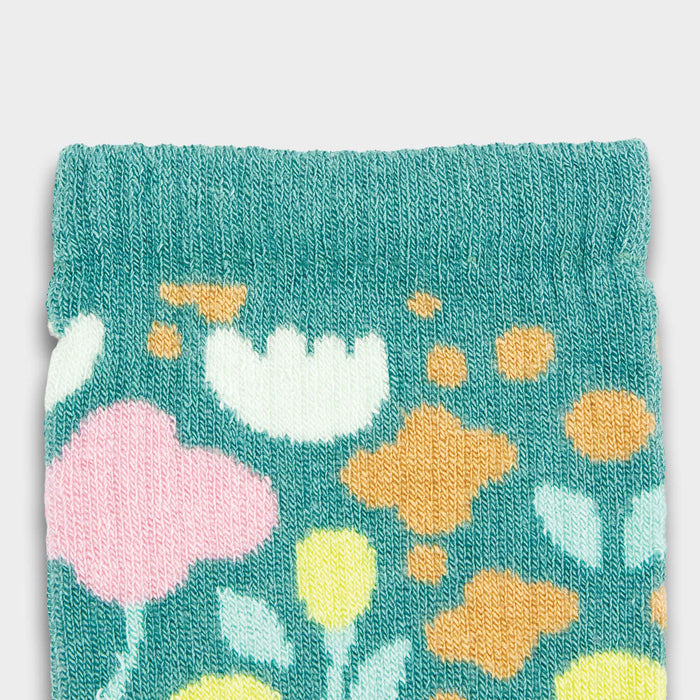Jolly Knitted Bamboo Kids Socks - A close-up of light teal kids' socks featuring a colourful floral pattern in pink, yellow, and white.