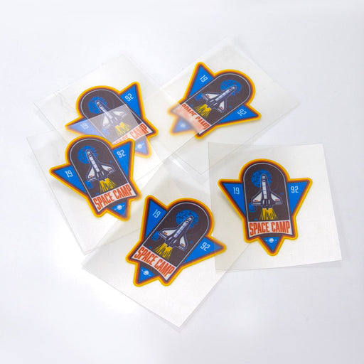 Prism Print - 50 x 50mm Sticker - A collection of five 50 x 50mm stickers featuring a rocket and 'Space Camp' design, with vibrant blue, orange, and white colours.