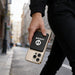 5000mAh Magnetic Wireless  Power Bank - A 5000mAh magnetic wireless power bank in black is attached to a gold smartphone, held by a person walking on a street.