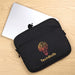Rime Laptop Sleeve - A black laptop sleeve featuring a logo design, with a silver laptop partially visible behind it on a wooden surface.