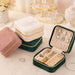 Velvet Jewellery Organizer - A velvet jewellery organiser in pink, green, and cream with compartments for rings and earrings. It features a logo.