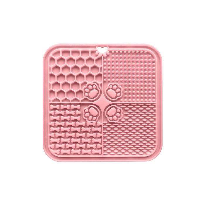 4-Section Dog Enrichment Lick Mat - A pink, four-section dog enrichment lick mat featuring various textured patterns, including paw prints and bones, with a central hole.