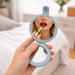 Round Folding Pocket Mirror - A round, light blue folding pocket mirror held in a hand, reflecting a person applying red lipstick.
