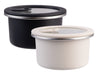 Oasis Microwave Safe Round S/S Container 680ml - A round microwave-safe stainless steel container set in black and white, each with a transparent lid and a branding logo.