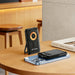 10000mAh 6 in 1 Magnetic Wireless  Power Bank - A black 10000mAh 6 in 1 magnetic wireless power bank sits upright on a wooden table next to a smartphone and a book.