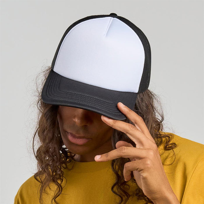Rapper-S Recycled Polyester - A black and white trucker cap featuring a flat brim and mesh back, worn by a person with long, curly hair.