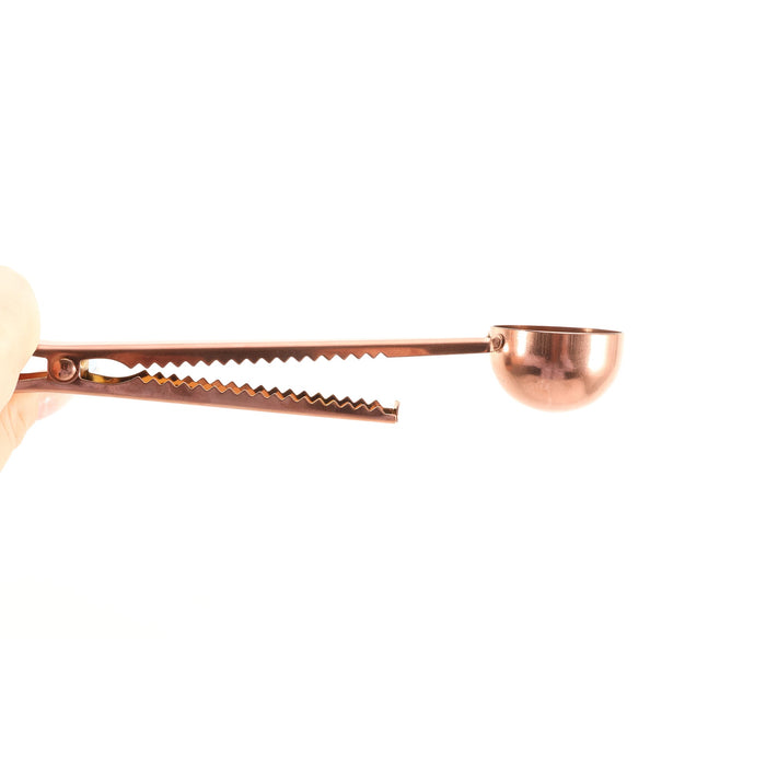 Coffee Measuring Spoon With Clip - A copper coffee measuring spoon with a clip, featuring a curved scoop and textured grip for convenience.