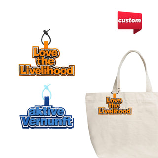 Custom Felt Logo Hanging Tag - Two custom felt hanging tags in orange and blue, featuring logos, attached to a cream-coloured tote bag.