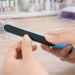 PS Nail File - A nail file with a blue handle and a black filing surface is being held in a person's hand.
