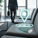 MiTag Duo Passport Holder with Global Tracking Tag - A teal passport holder sits on a grey sofa in an airport lounge, with a logo and a tracking symbol above it.