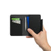 MiTag Duo Passport Holder with Global Tracking Tag - A black passport holder is shown, holding credit cards and a pen inside. It features a sleek, minimalist design.