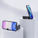 Catania Retractable 60W Fast Charging and Data Cable Set - A mobile phone stand in black, holding a smartphone, displayed on white pedestals against a light background.