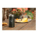 Arctic Zone Titan Thermal HP Slim Cooler 350ml - A drink bottle in black with a stainless steel top, placed on a table next to a platter of snacks.
