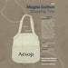 Maglia Cotton Shopping Tote - A cotton shopping tote in cream with mesh panels and a logo, featuring sturdy handles and a spacious interior.